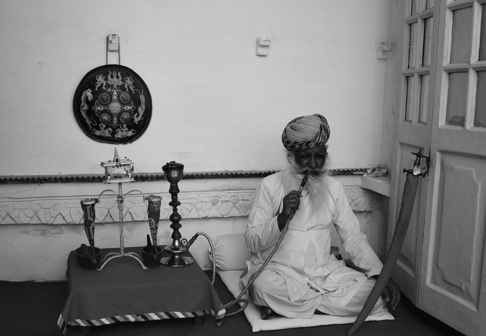 A man sitting on the floor with a pipe