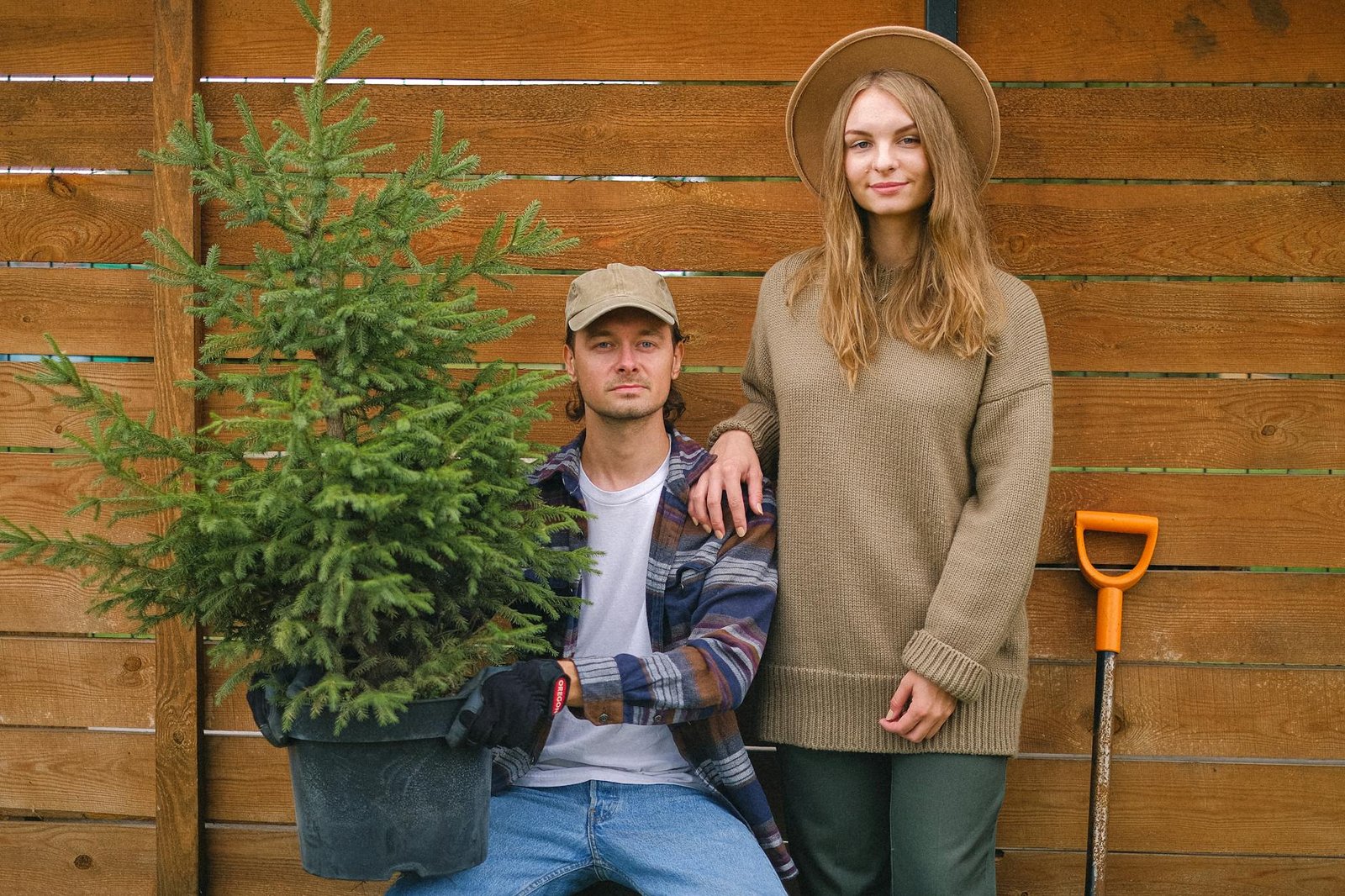 Positive girlfriend putting hand on shoulder of boyfriend in farm