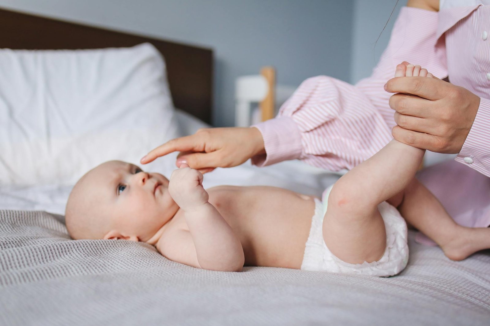 Crop mother playing with baby